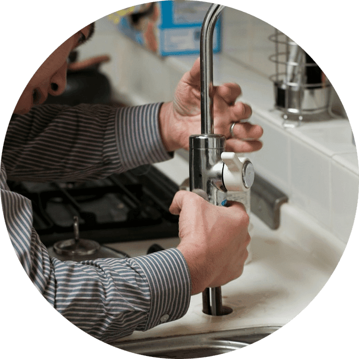 Plombier installant un robinet
